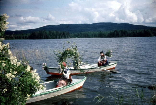 Historisk bild från Dalagården med roddbåtar och midsommarfirande