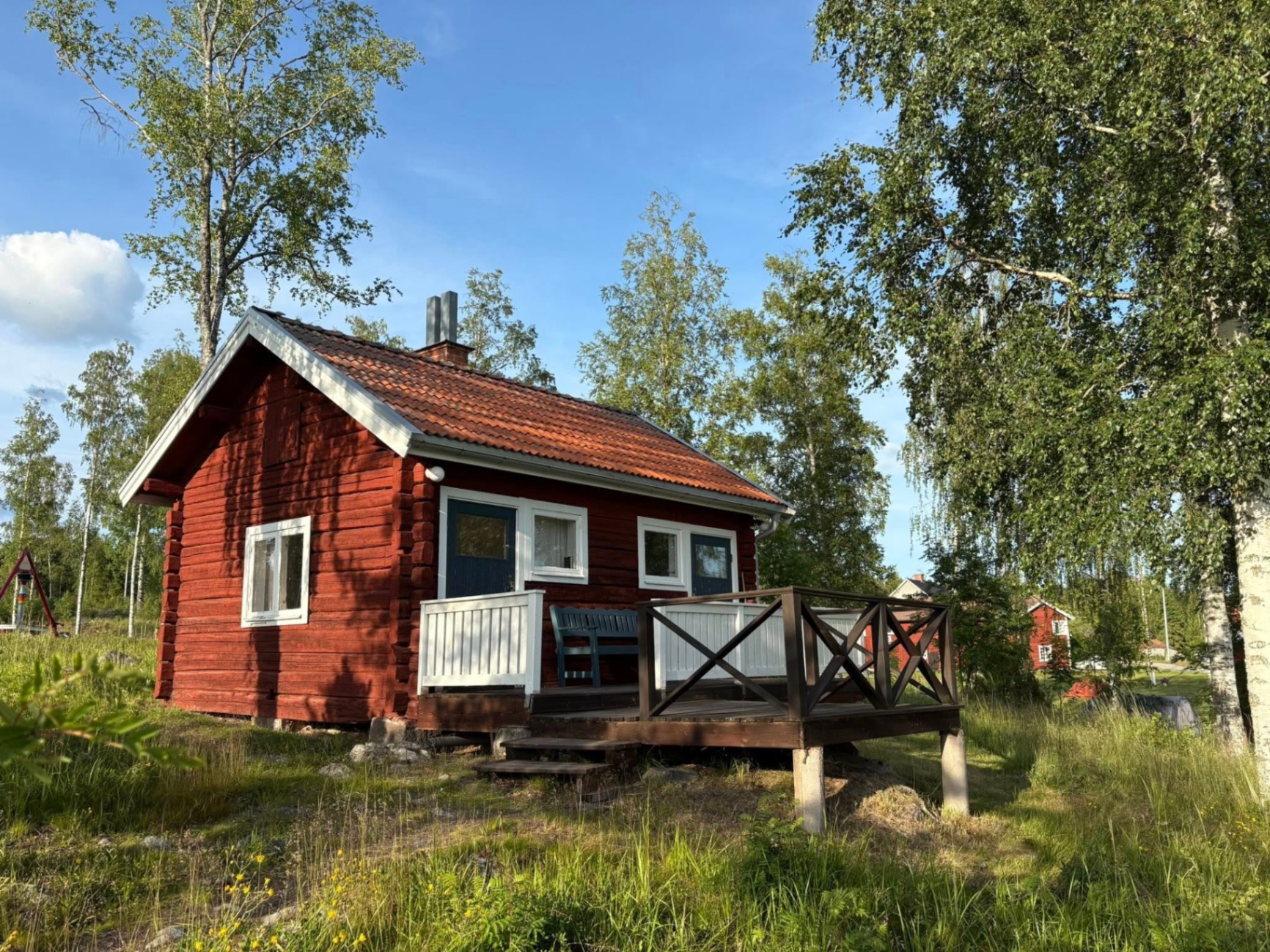 Hyddan – röd stuga med veranda på Dalagården