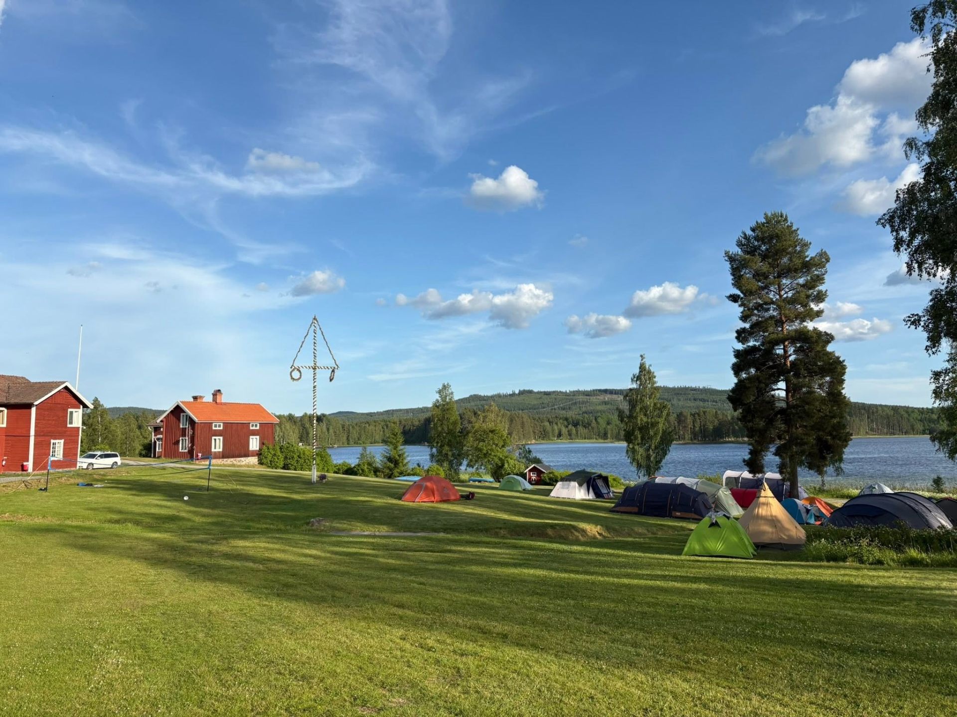 Tältplatser på gräsmattan vid midsommarstången med utsikt över Liljan