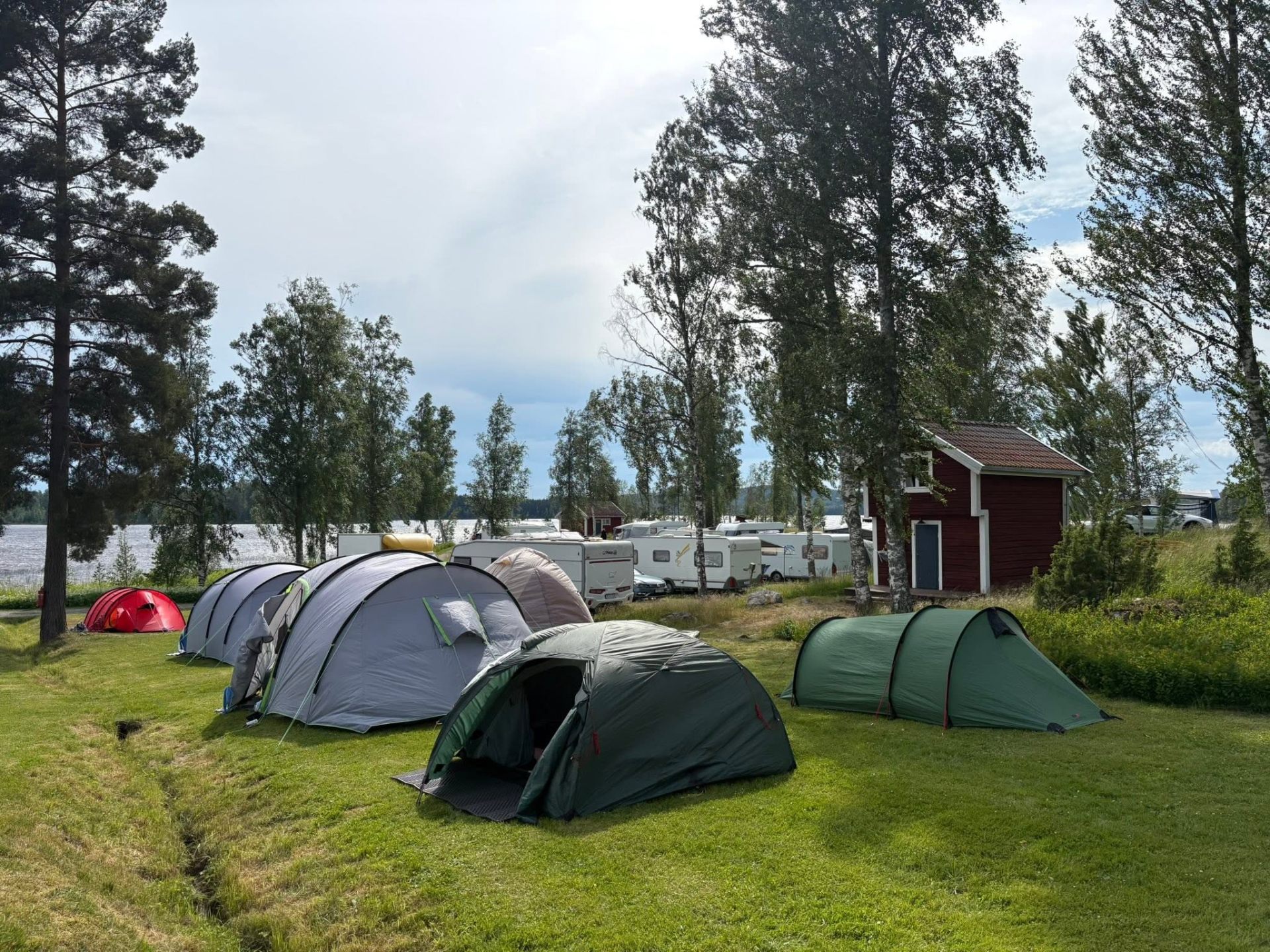 Tält och husvagnar på ställplatsen vid sjön Liljan